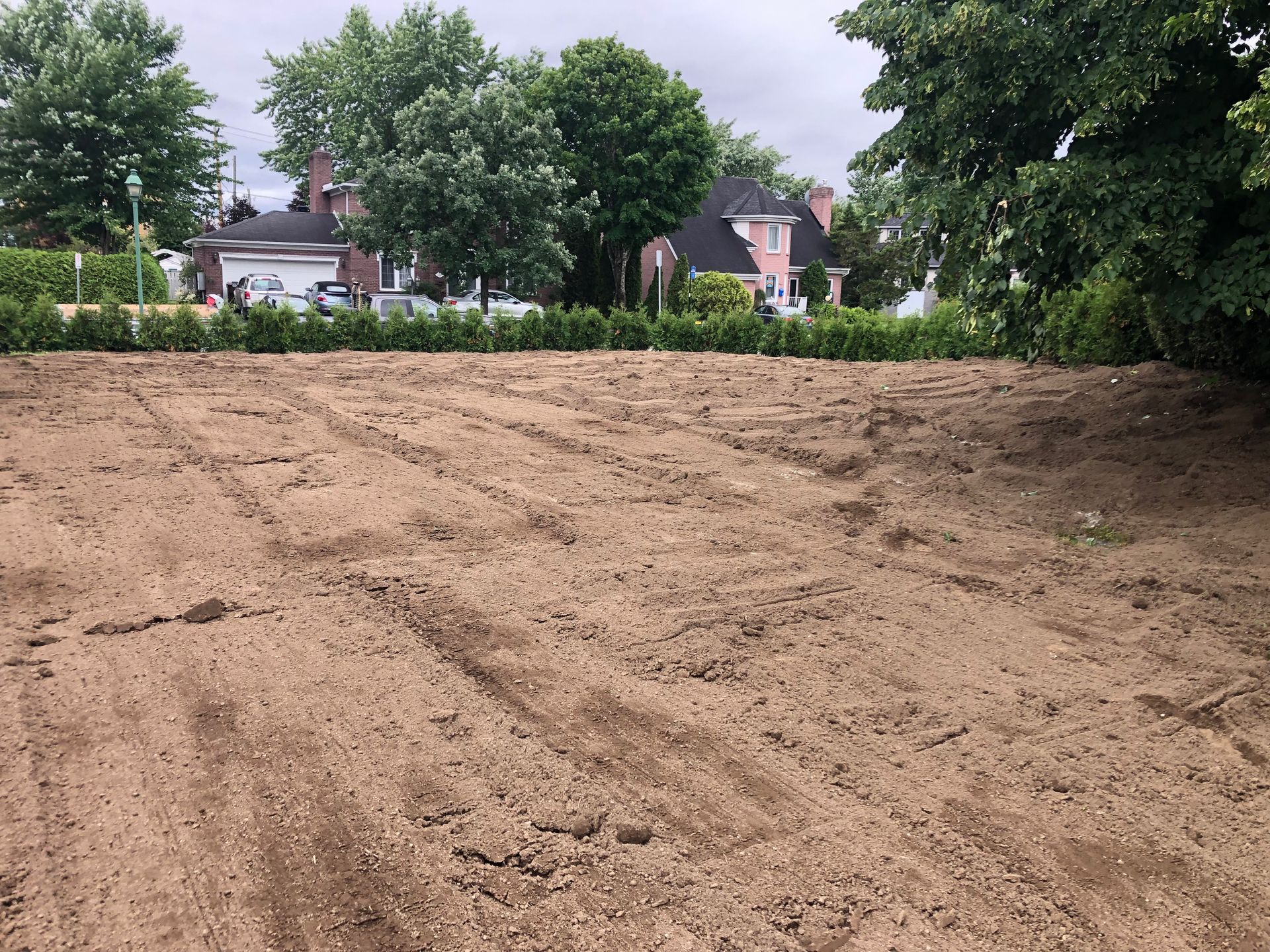 Un champ de terre avec une maison en arrière-plan