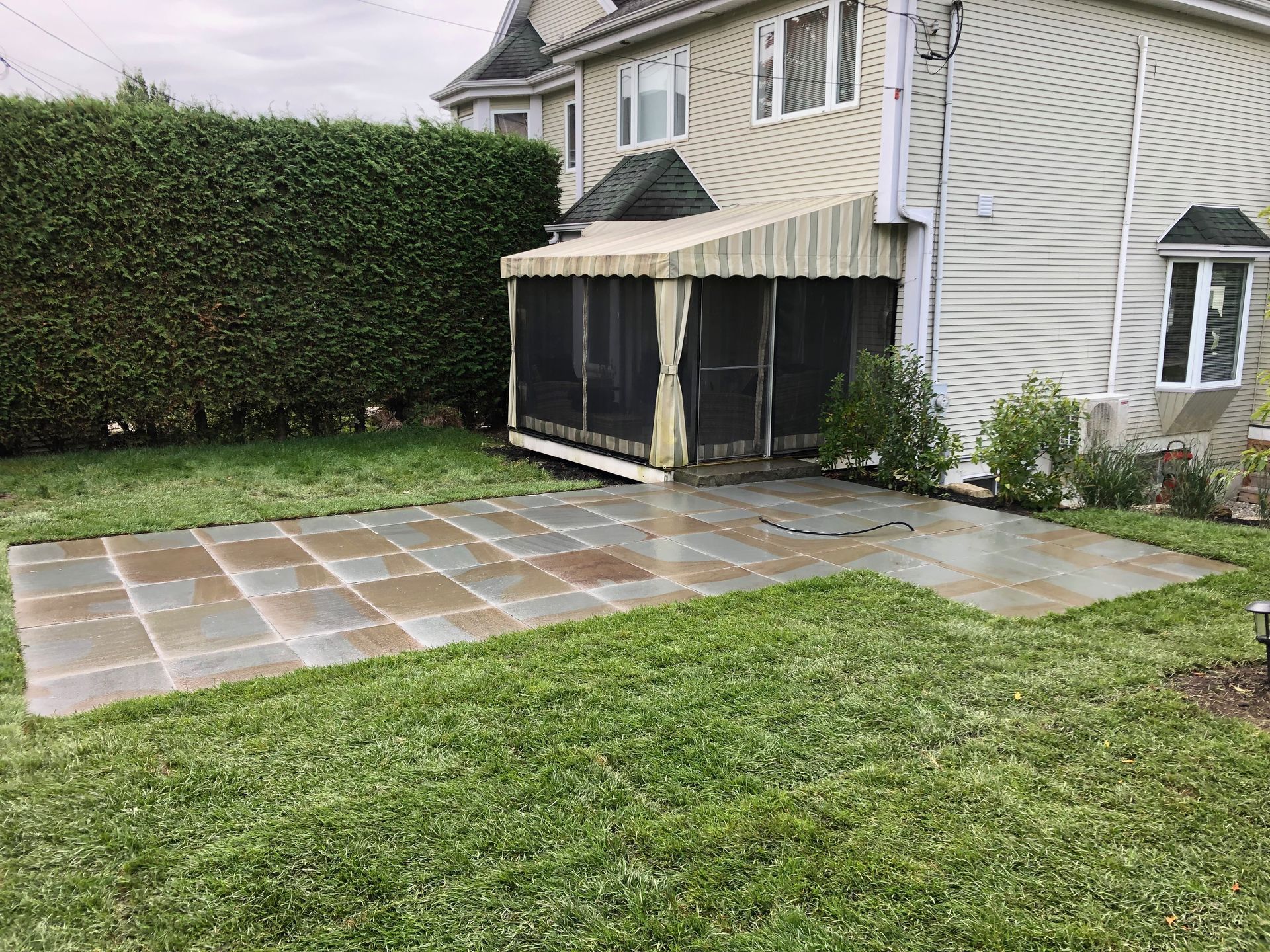 Il y a un porche grillagé dans l'arrière-cour d'une maison.