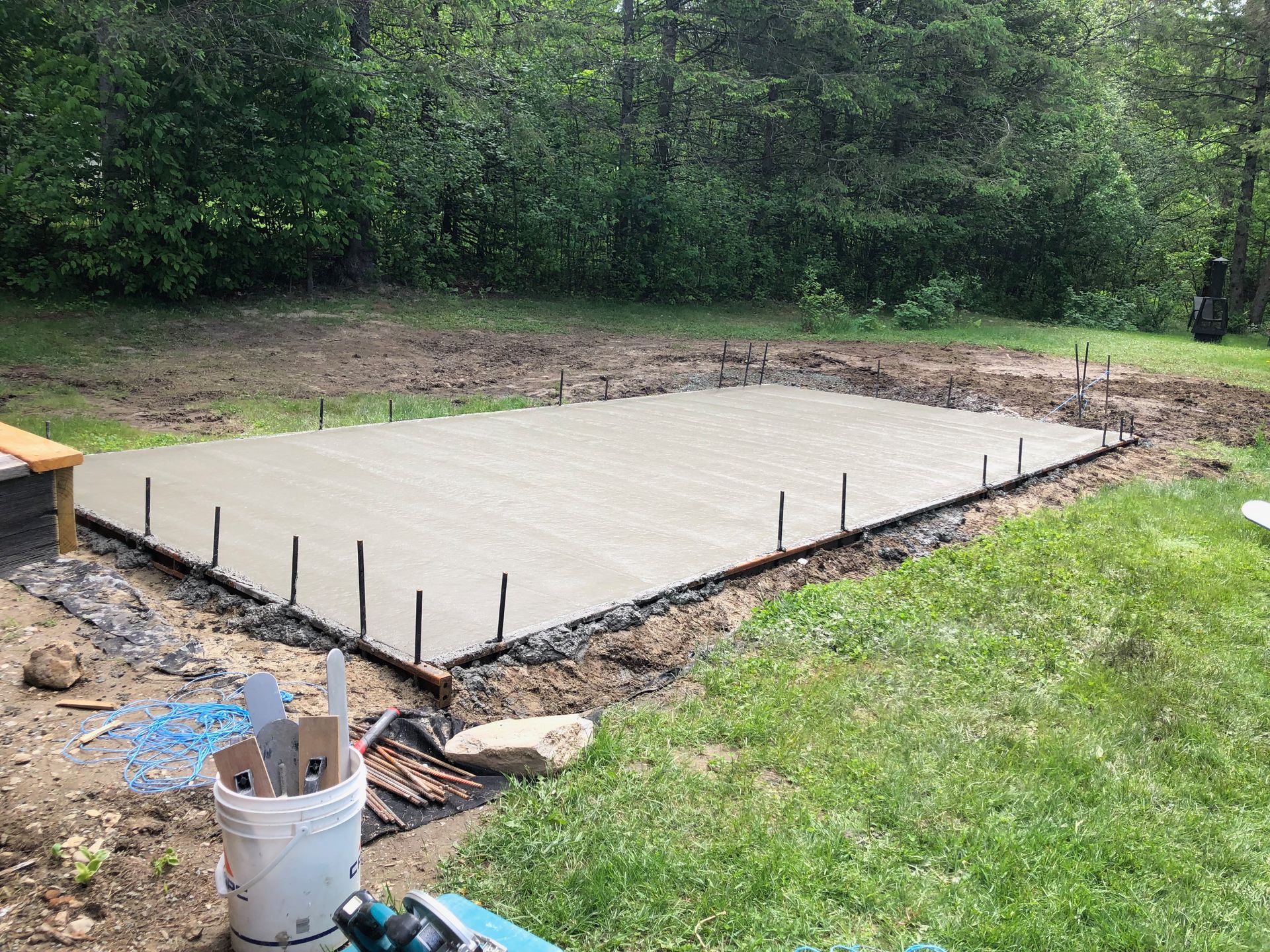 Une fondation en béton est en cours de construction dans une cour arrière.