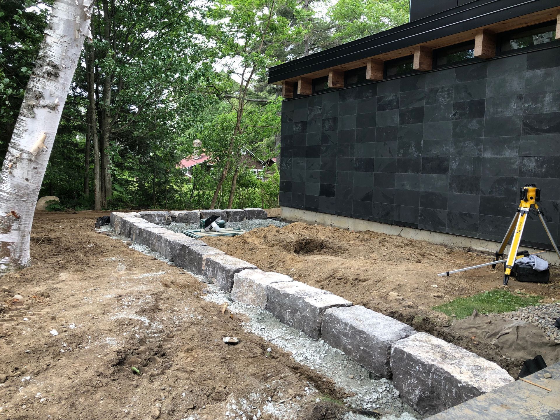 Un trépied est posé dans la terre devant un bâtiment.