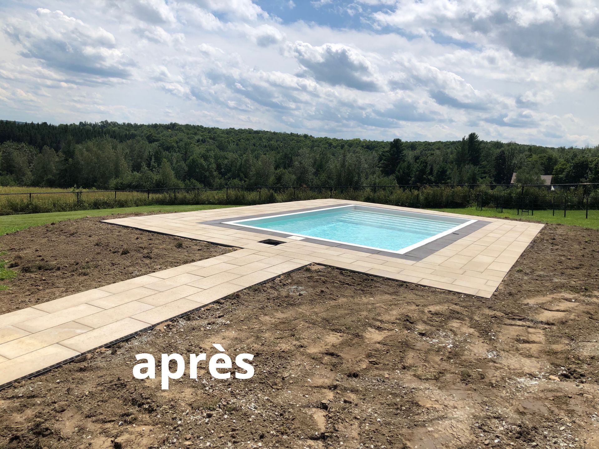 Il y a une piscine au milieu d'un champ de terre.