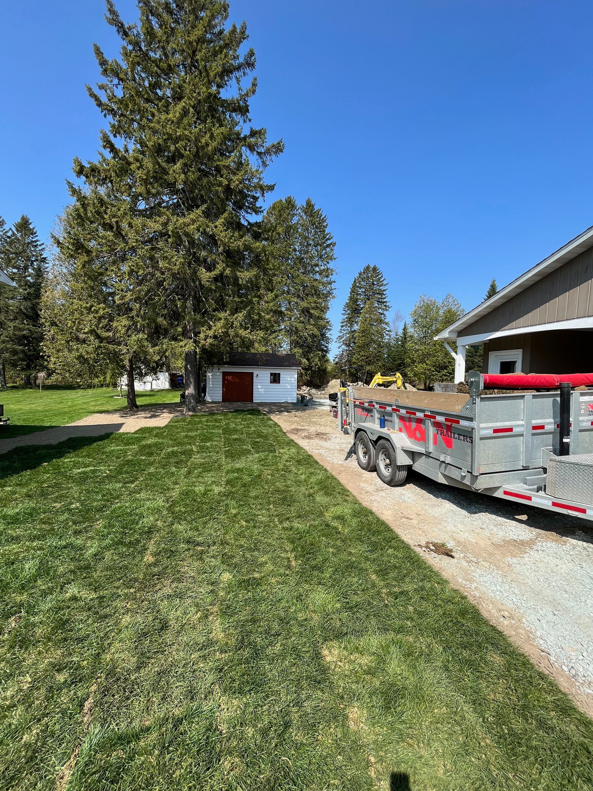 Une remorque est garée dans une allée à côté d'une maison.