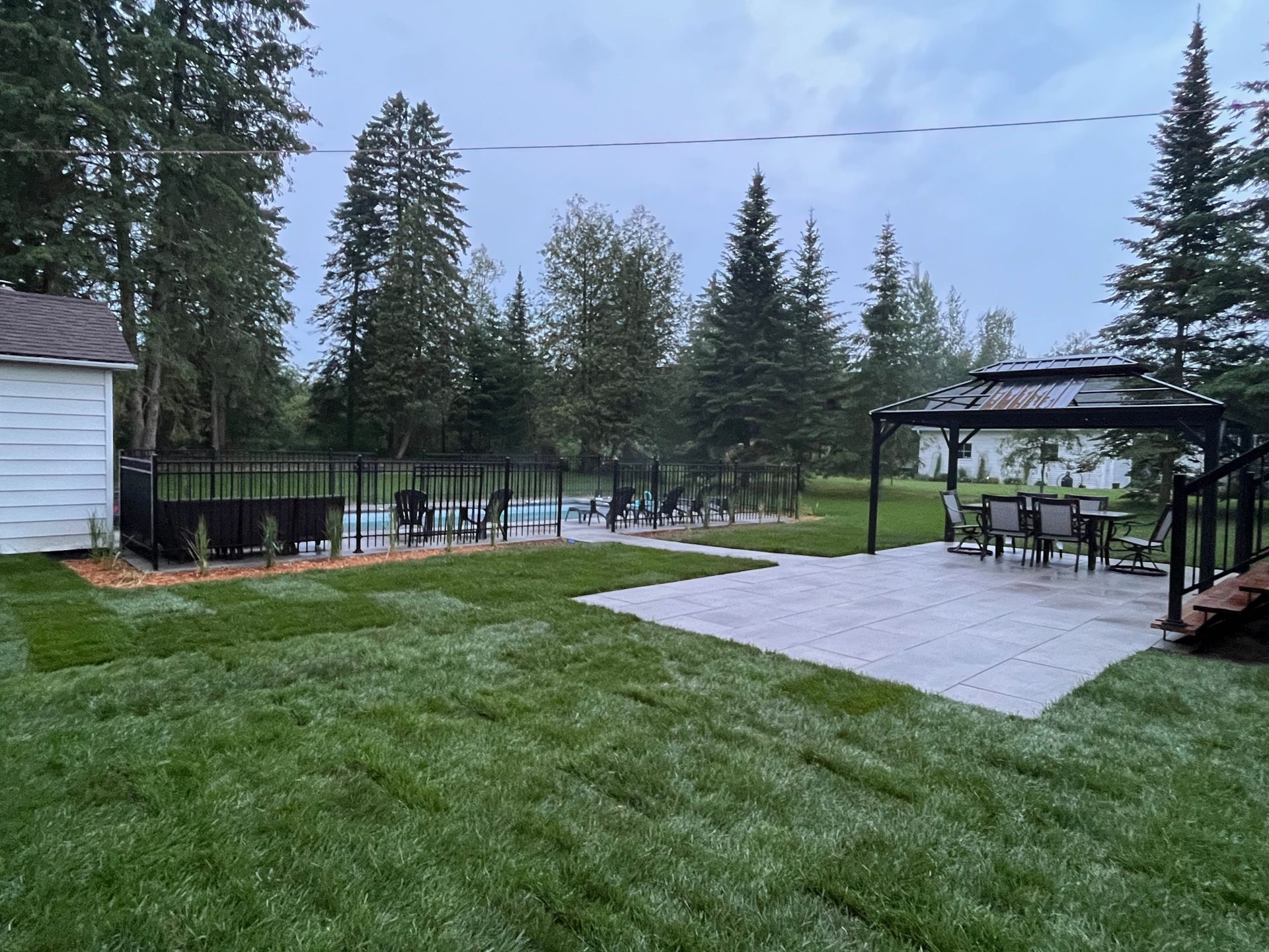 Il y a un belvédère dans l'arrière-cour avec une piscine en arrière-plan.