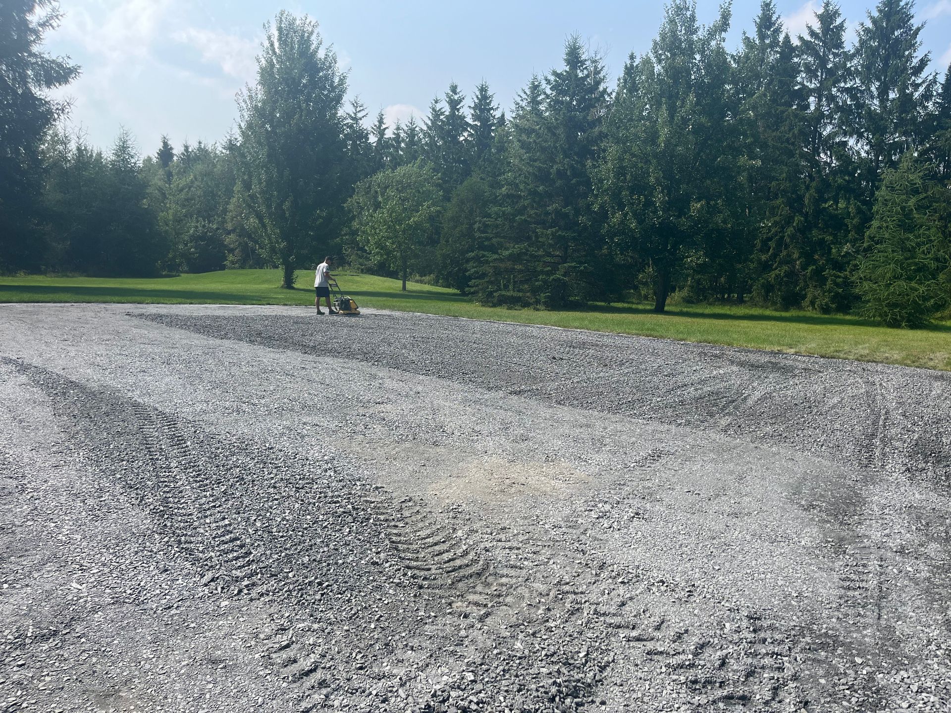 Une allée de gravier avec des arbres en arrière-plan