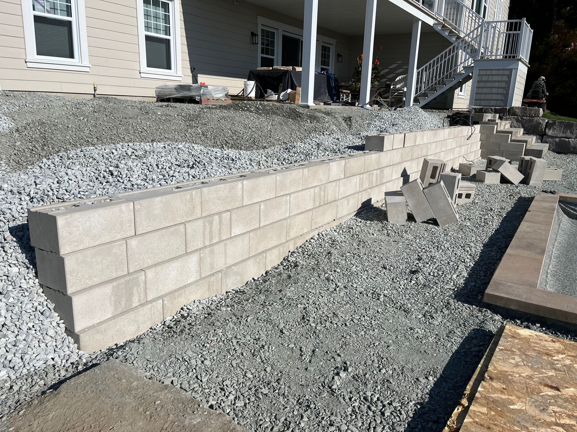 Un mur de briques est en train d'être construit devant une maison.