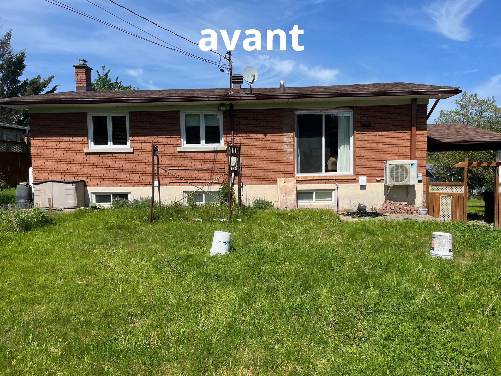 Une maison en briques avec beaucoup d'herbe devant.