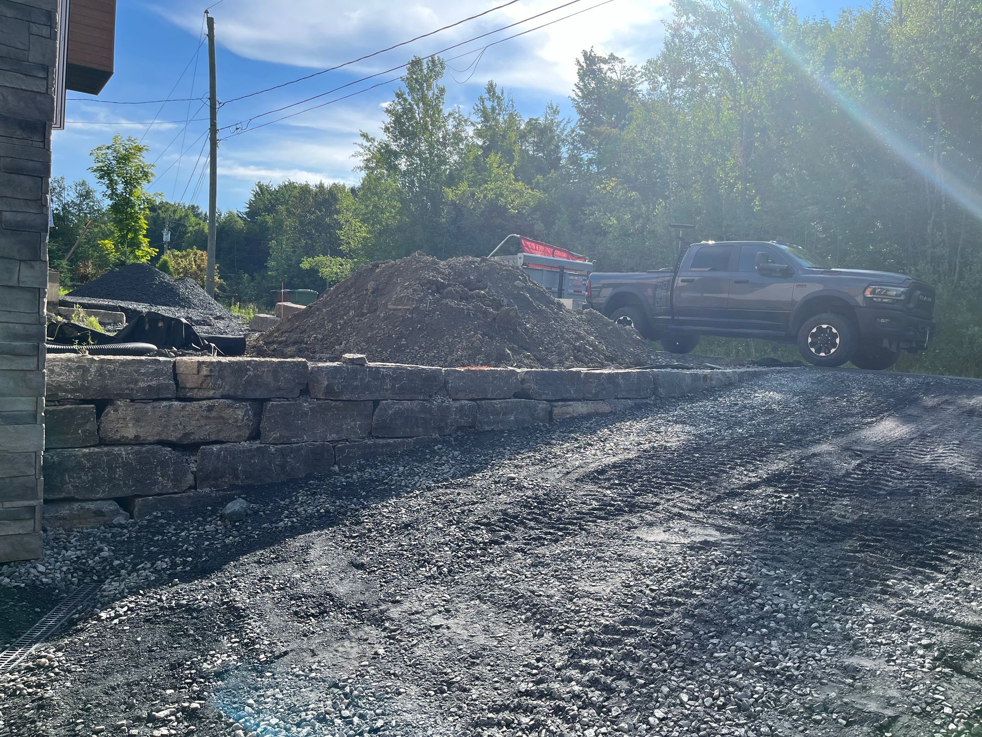 Un camion est garé devant un tas de terre.