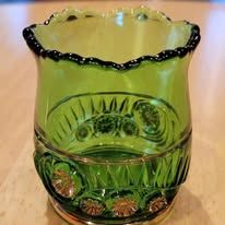 Green glass decorative container with floral design.