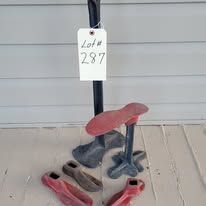 Cast iron tools with a red seat, black pole and tag 