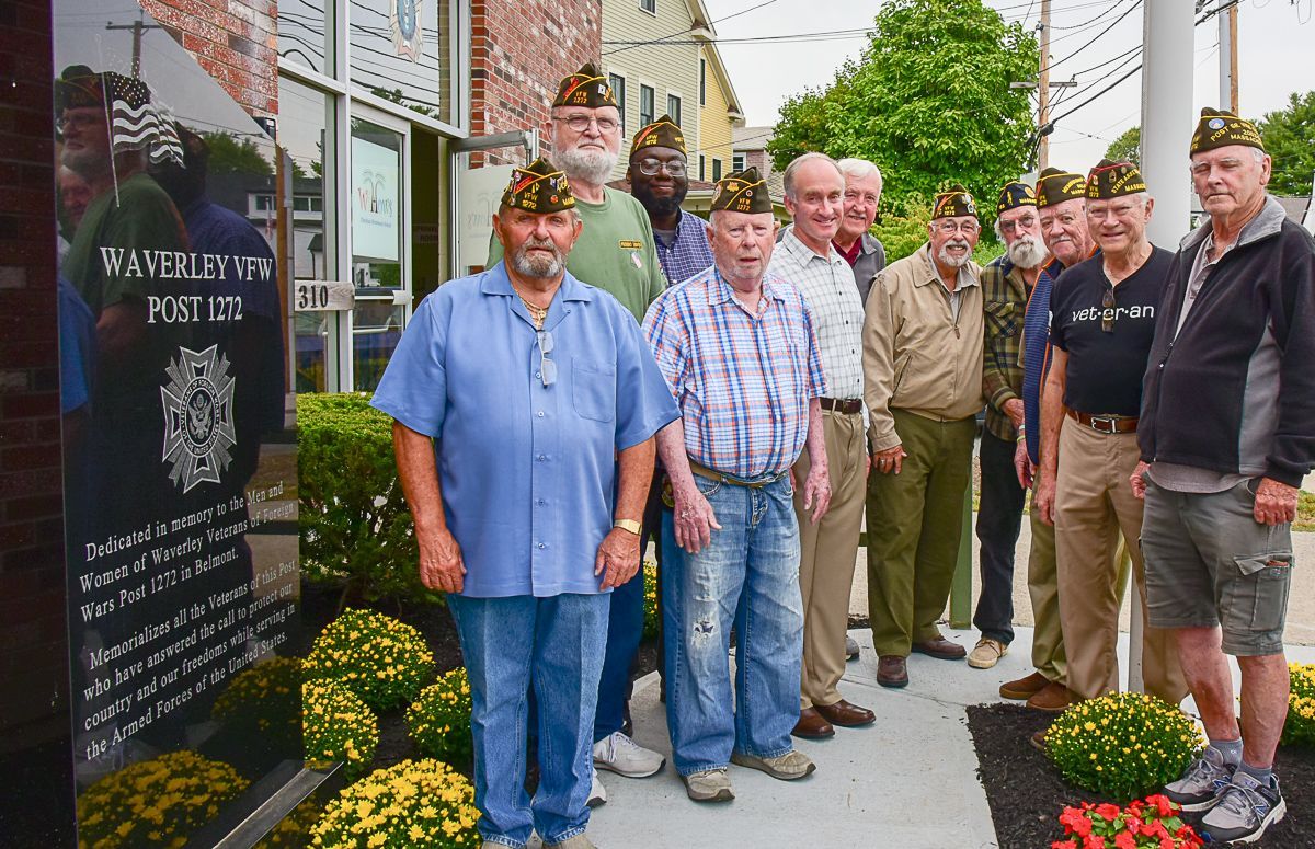 A group of men in military uniforms are standing in front of a building.