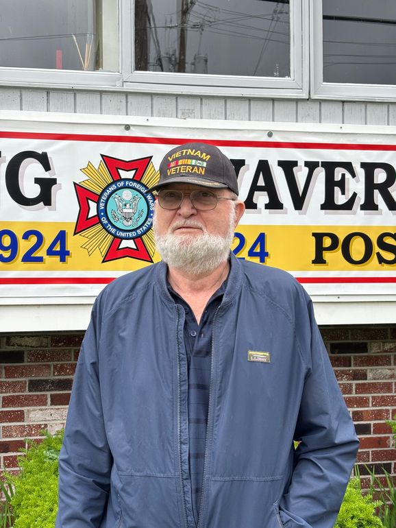 A man with a beard wearing a military hat