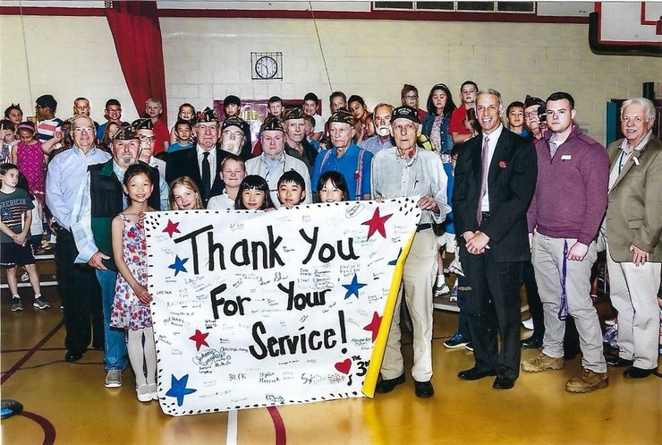 A group of people holding a sign that says thank you for your service