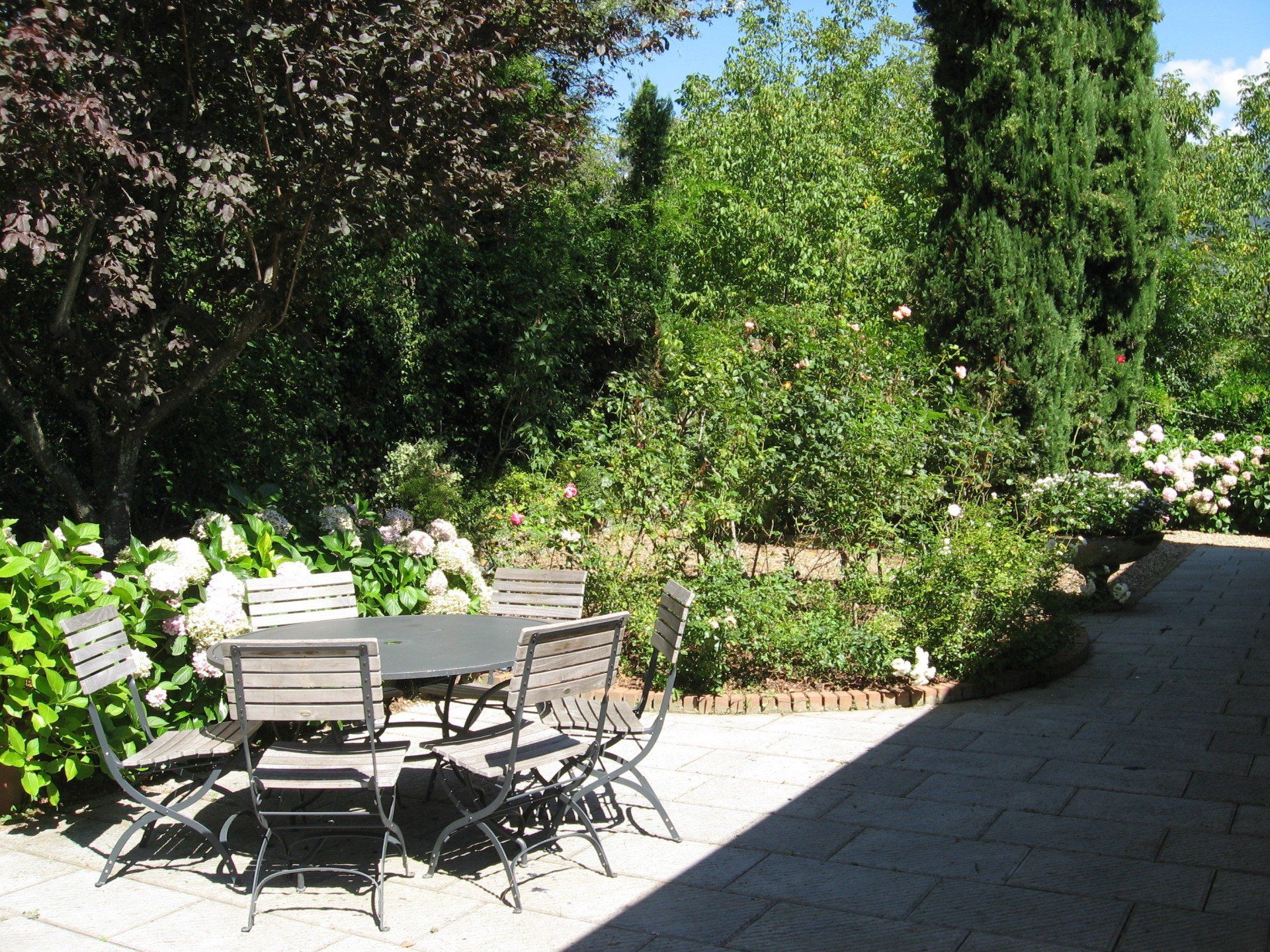 Eettafel met stoelen op terras buiten bij de keuken