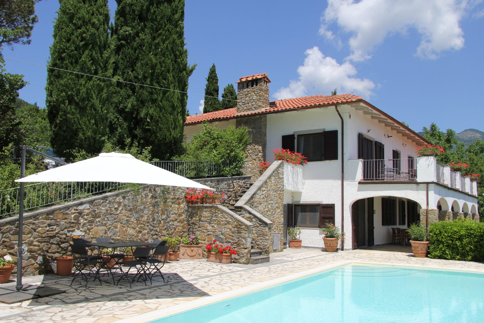 Zijaanzicht op het huis met het zwembad op de voorgrond