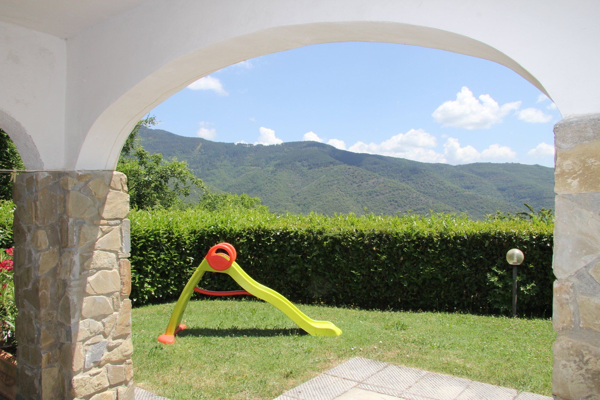 Tuin en glijbaantje met de heuvels op de achtergrond