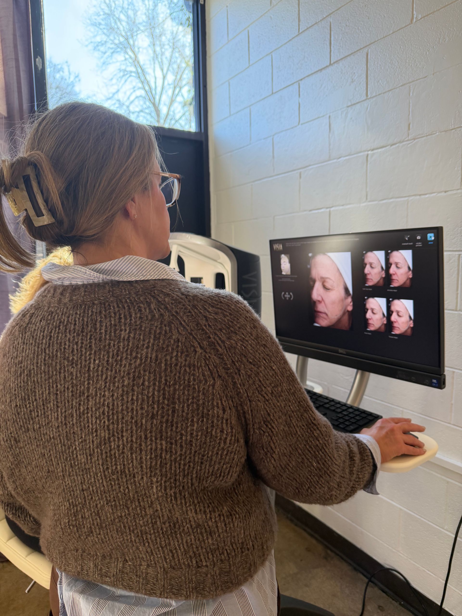 A woman is looking into the camera while holding her hands together. 