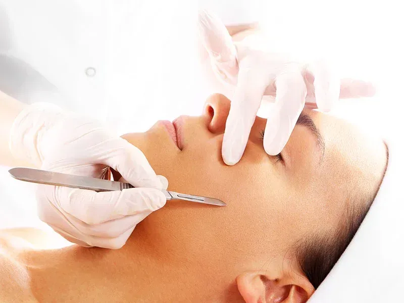 A woman with curly hair and hoop earrings is looking at the camera.