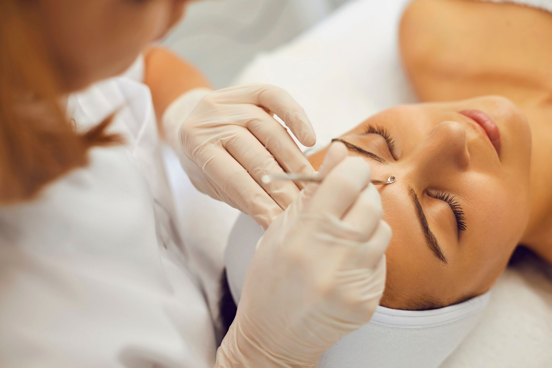 A woman is getting a facial treatment at a beauty salon.