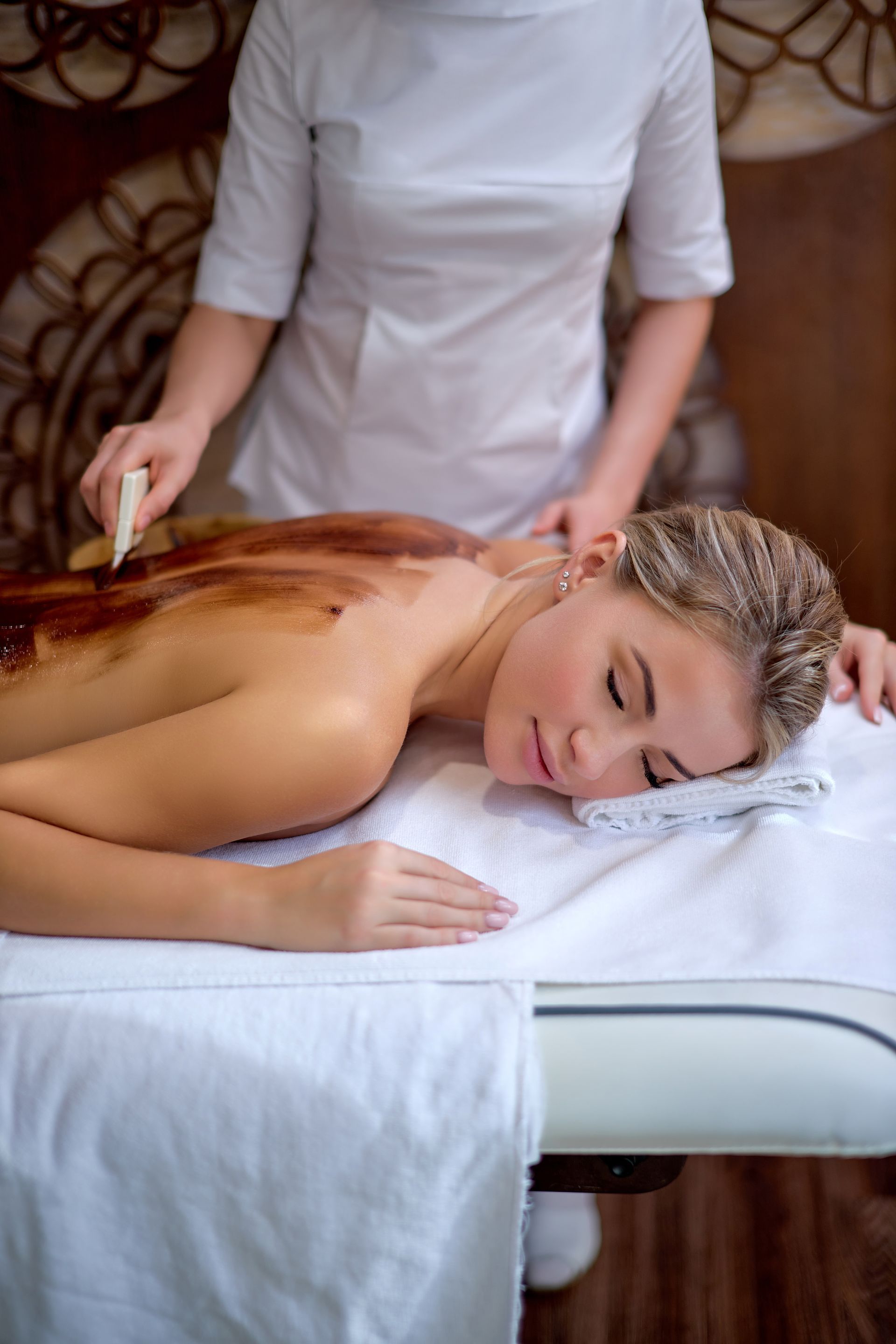 A woman is getting a chocolate massage at a spa.