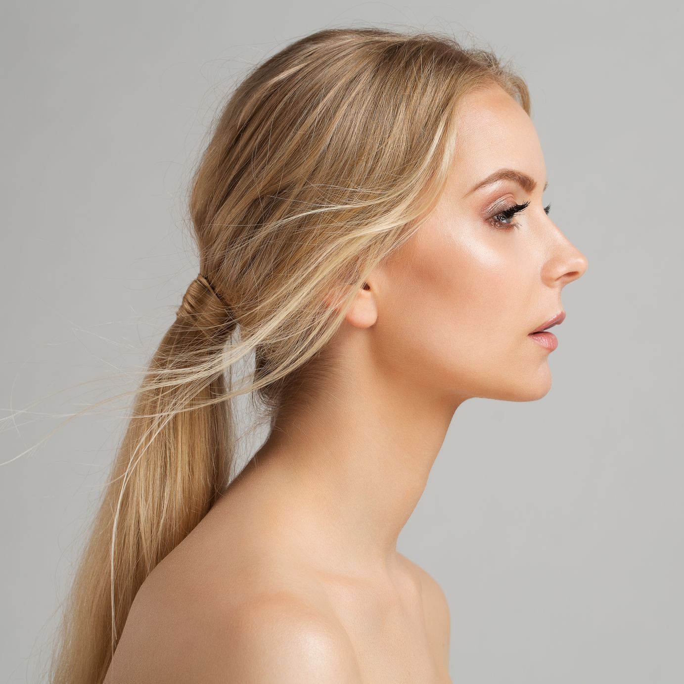 A woman with long blonde hair is wearing a ponytail.