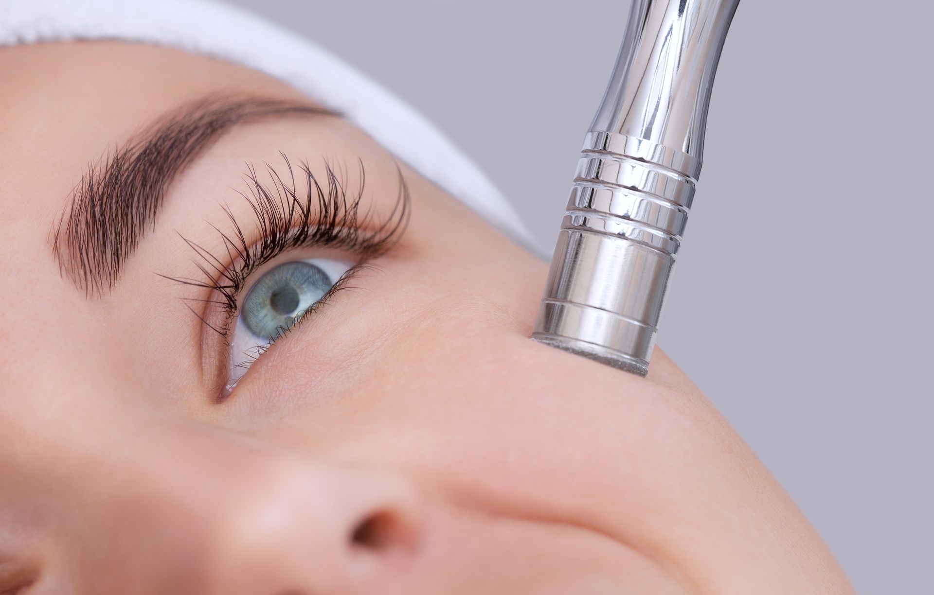 A woman is getting a facial treatment with a machine on her face.