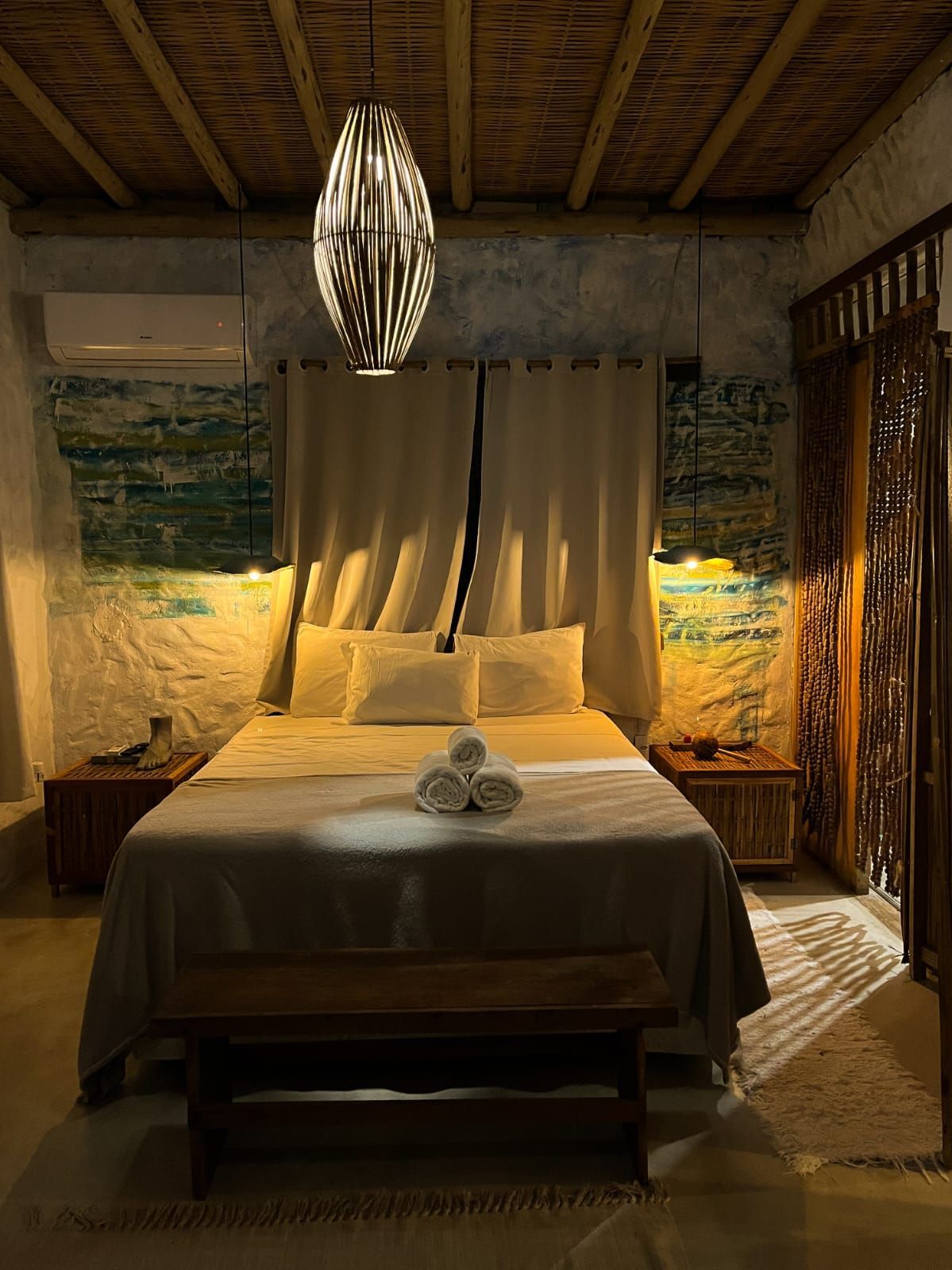 Há uma cama grande no meio do quarto. Pousada Quadradinho de Trancoso