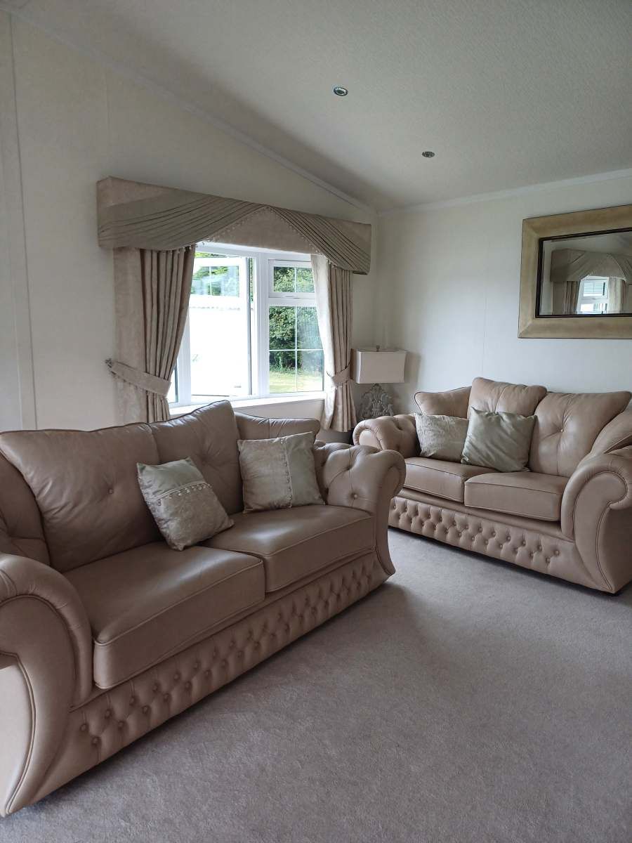 Bright living room with beige sofas, window seat, and neutral decor