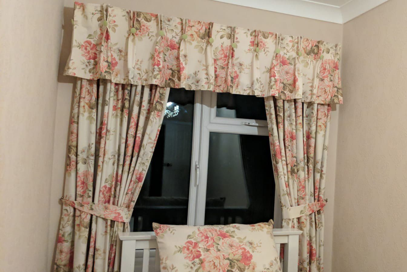 Floral curtains framing a dark window in a beige room