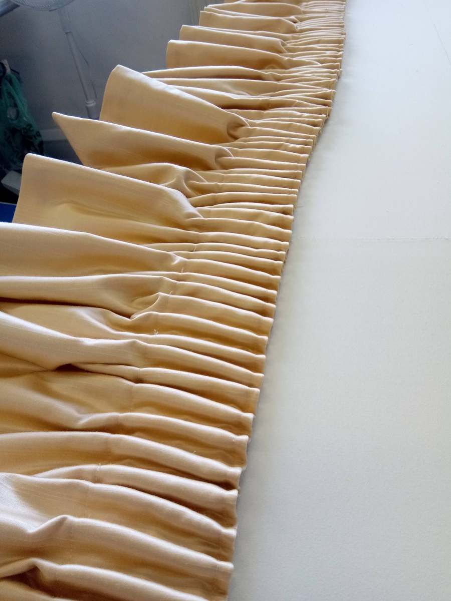 Rows of beige pleated paper cup sleeves lined diagonally on a white surface