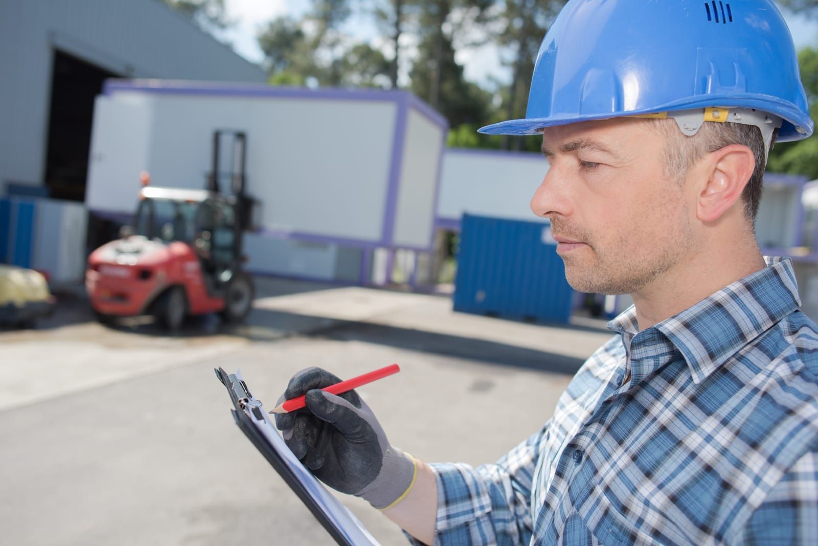 Forklift service technician checking equipment as part of a regular maintenance schedule.