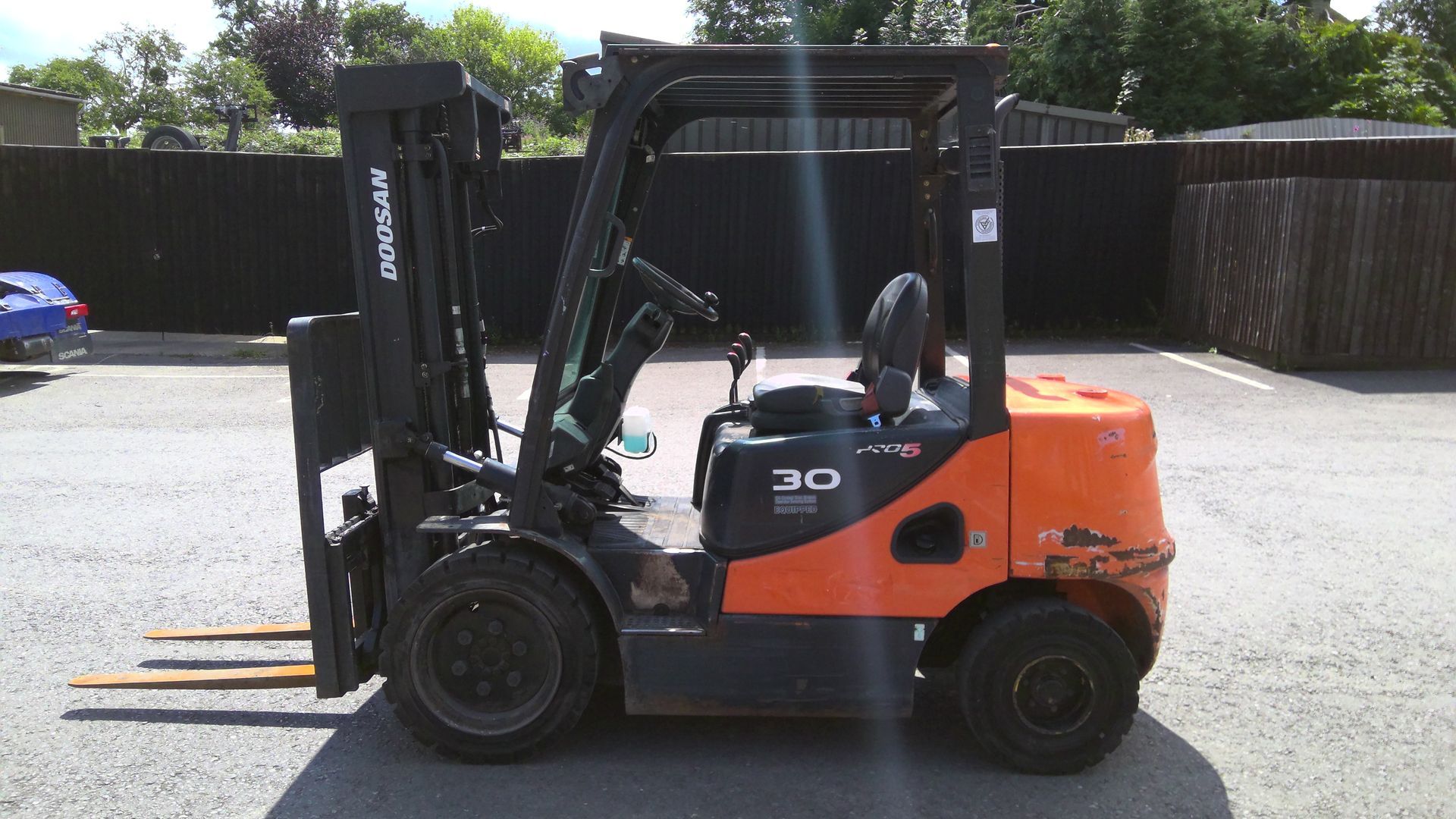 A forklift is parked in front of a brick building