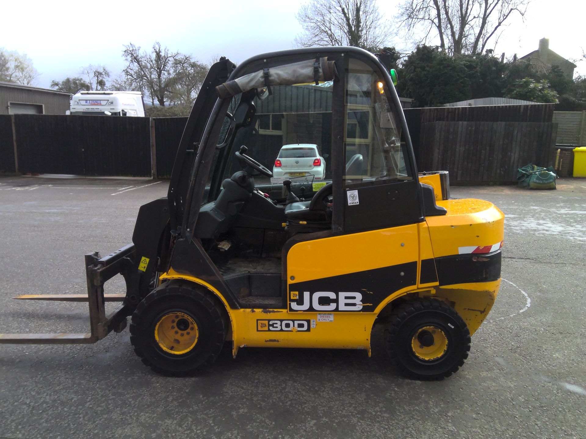 A yellow forklift is parked in front of a brick building