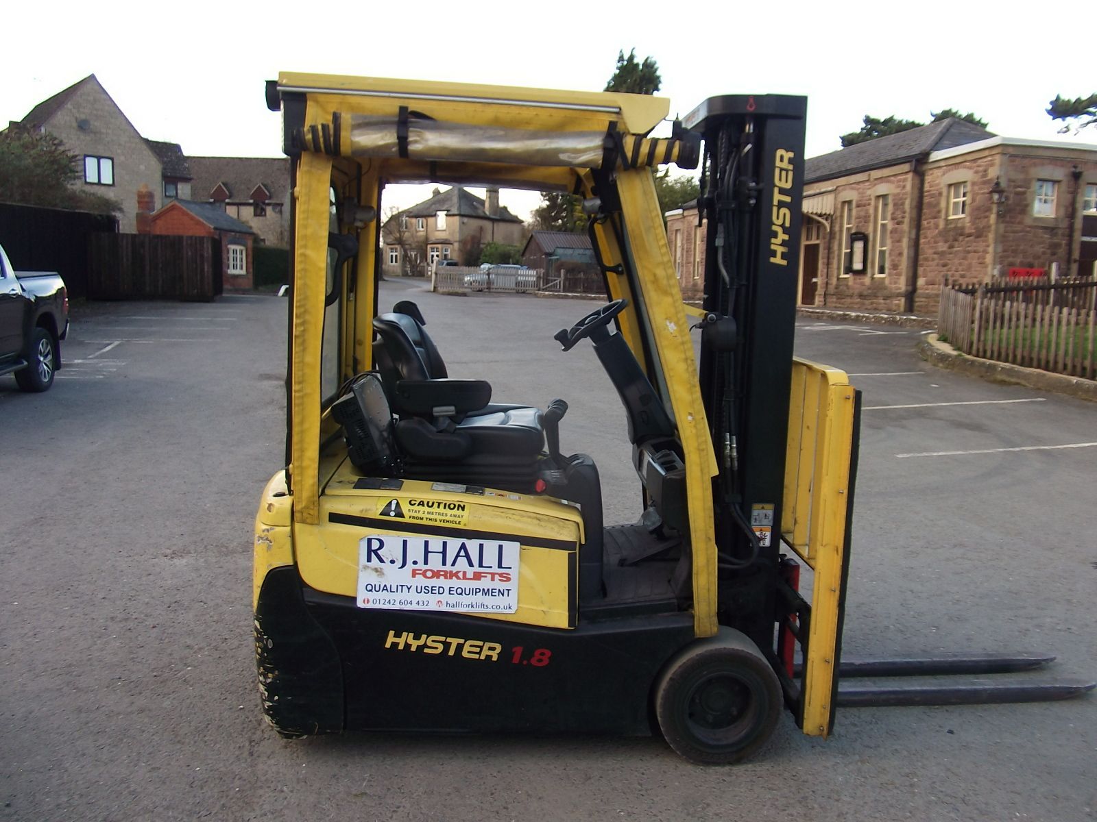 A yellow hyster forklift is parked in a parking lot