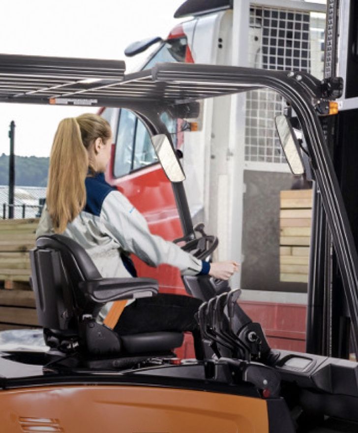Certified technician performing a forklift safety inspection in a UK warehouse, checking hydraulic and brake systems to ensure compliance and performance