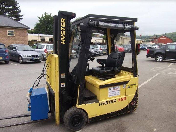 A yellow hyster forklift is parked in a parking lot