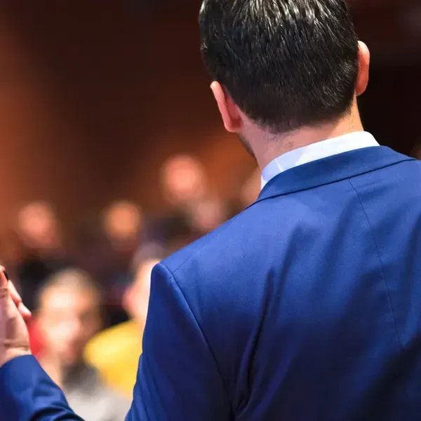 A man in a blue suit is giving a speech