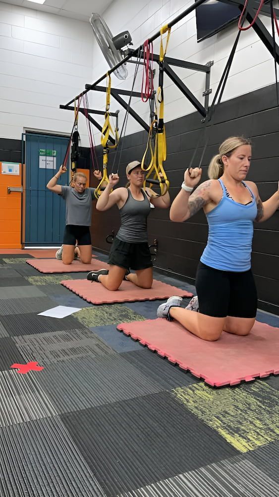Three Groups Of People Are Doing Exercises On Mats In A Gym — Ultimate Results Training in Aitkenvale, QLD