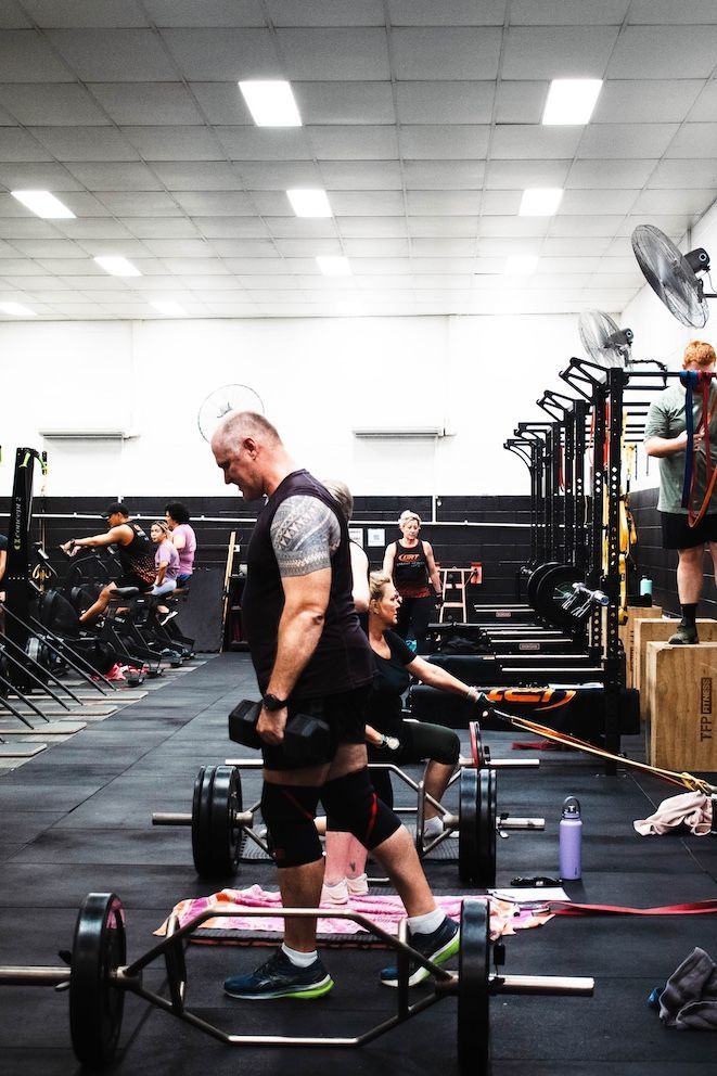 Man Lifting Dumbells In Gym — Ultimate Results Training in Aitkenvale, QLD