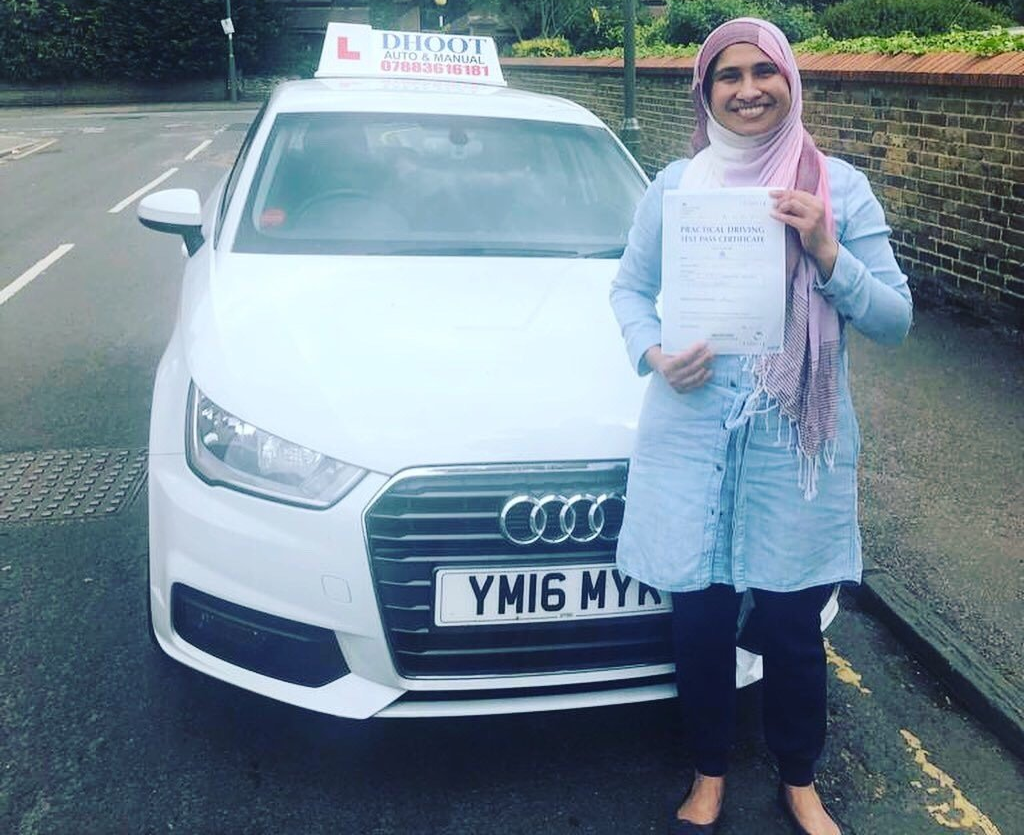 woman holding pass certificate in front of car