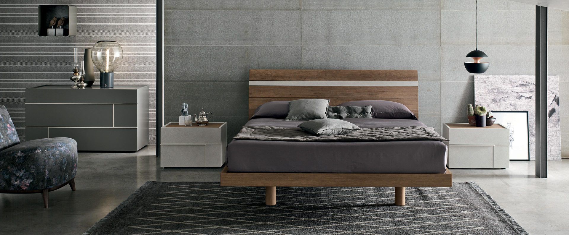 Una camera da letto con un letto, una cassettiera, un comodino, una sedia e un tappeto.