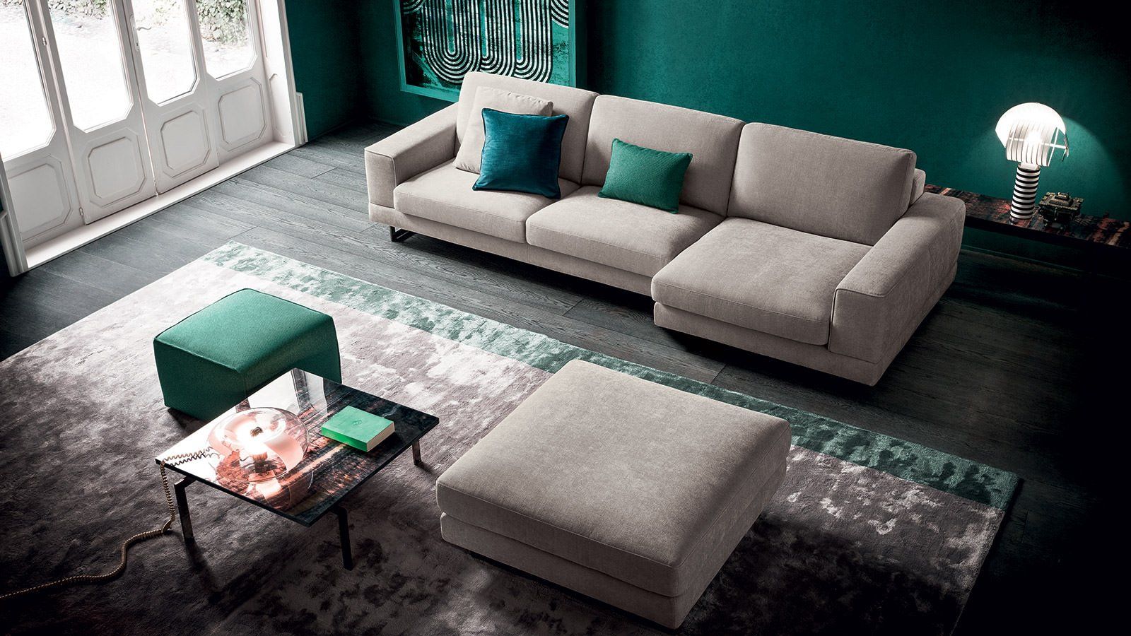 Un soggiorno con un divano, un pouf e un tavolino da caffè