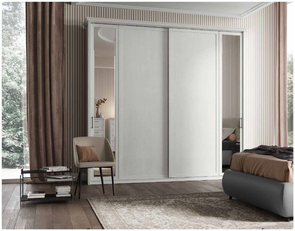 Una camera da letto con porte scorrevoli bianche e un letto