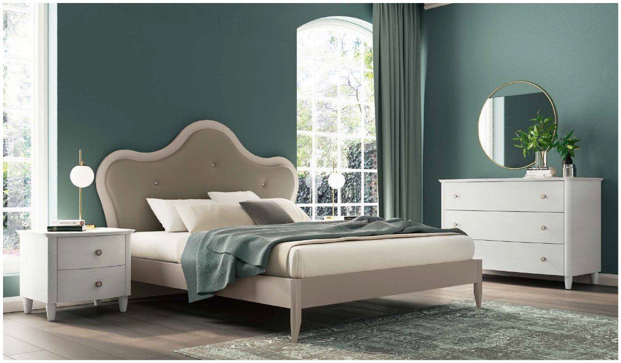 Una camera da letto con un letto, un comodino, una cassettiera e uno specchio.