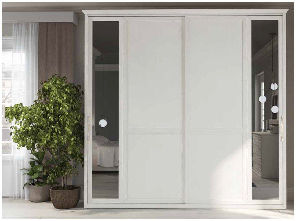 Un armadio bianco con ante scorrevoli e specchi in una camera da letto.