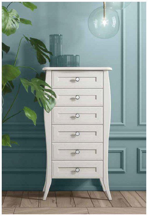 Una cassettiera bianca è appoggiata davanti a una parete blu.