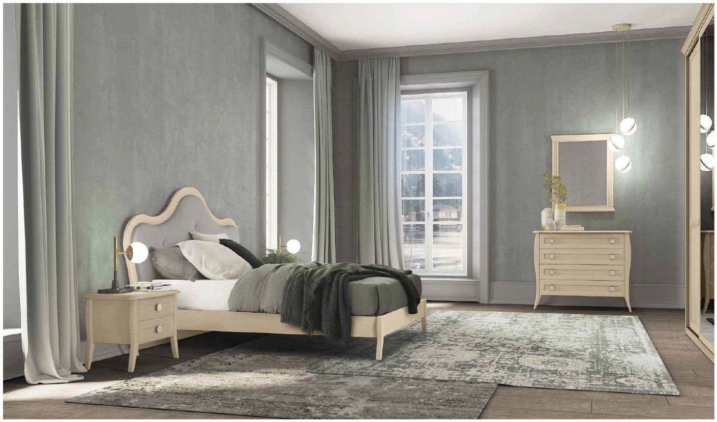 Una camera da letto con un letto, un comodino, una cassettiera e uno specchio.