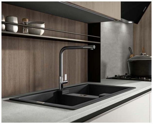 Una cucina con un lavandino nero e una stufa