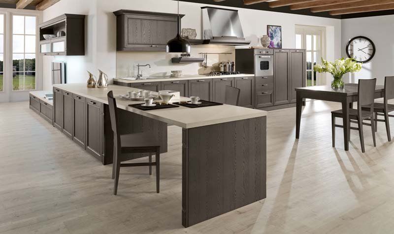 Una cucina con tavolo e sedie e un orologio sul muro