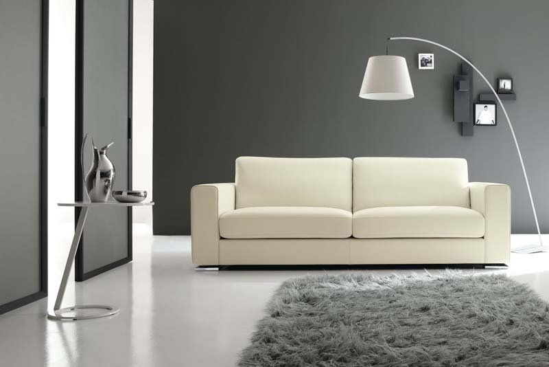 Un soggiorno con un divano bianco e una lampada