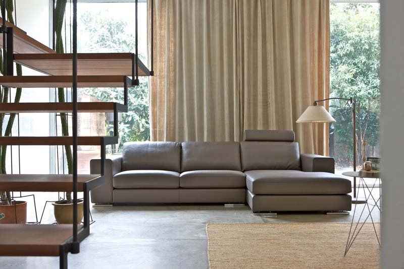 Un soggiorno con divano componibile e scale